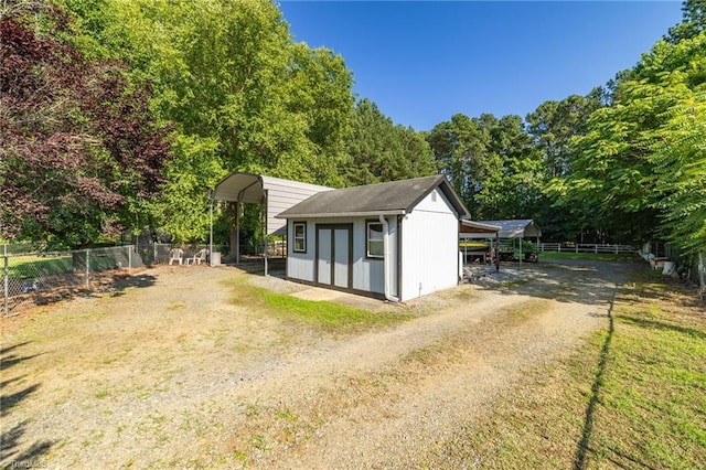 6937 US Highway 158, Stokesdale, NC 27357 - view of side of home featuring a carport, dirt driveway, and a storage shed