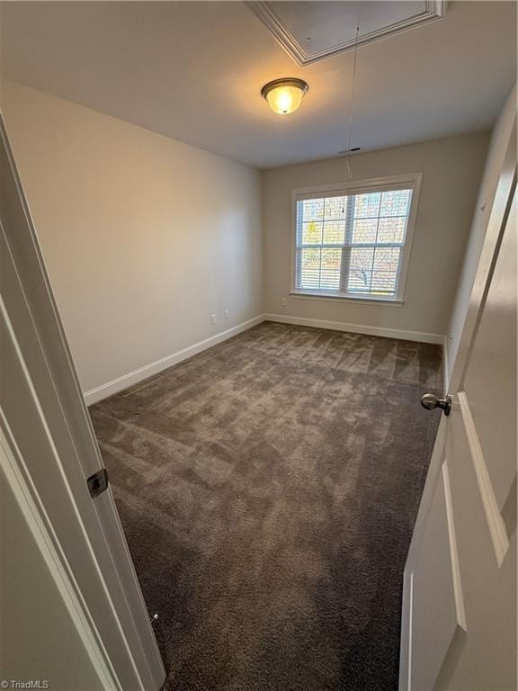 unfurnished room featuring dark carpet