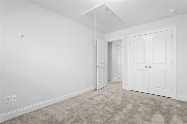 unfurnished bedroom featuring light colored carpet and a closet