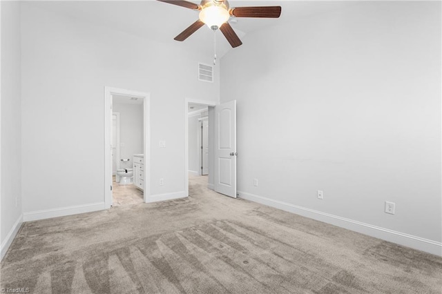 unfurnished bedroom featuring light carpet, high vaulted ceiling, ceiling fan, and ensuite bathroom