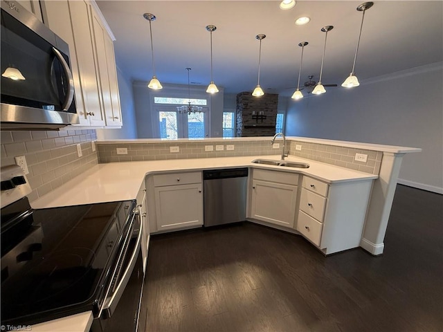 kitchen with hanging light fixtures, sink, kitchen peninsula, and appliances with stainless steel finishes