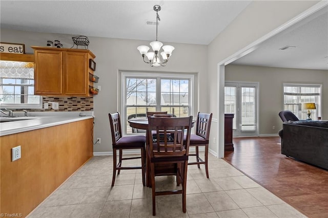 dining area with visible vents, a notable chandelier, baseboards, and light tile patterned floors