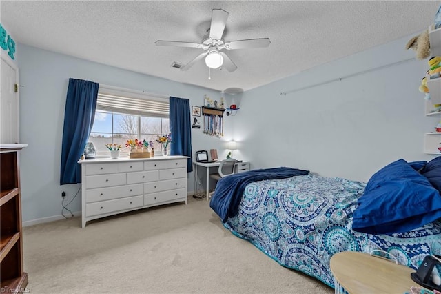 bedroom featuring light carpet, a ceiling fan, visible vents, and a textured ceiling