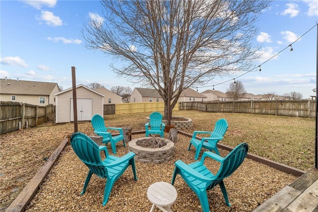 view of yard with a fire pit, a storage unit, an outdoor structure, and a residential view