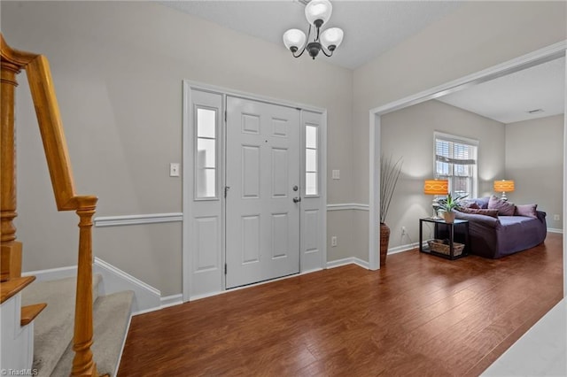 entryway with dark wood-style floors, baseboards, and stairway