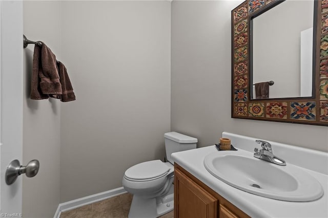 bathroom featuring baseboards, vanity, and toilet