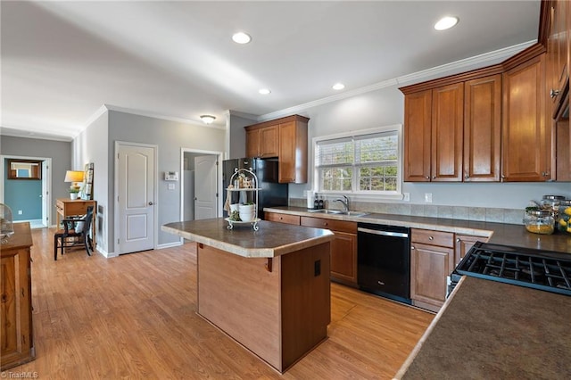 kitchen with brown cabinets, a center island, black appliances, a kitchen bar, and a sink