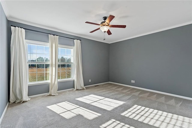 unfurnished room featuring light carpet, ornamental molding, a ceiling fan, and baseboards