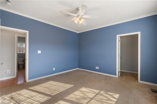 unfurnished bedroom with baseboards, a spacious closet, light carpet, and crown molding