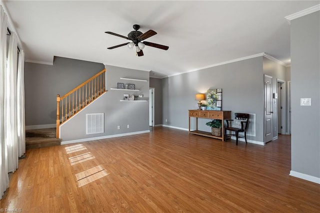 unfurnished living room featuring ceiling fan, wood finished floors, visible vents, baseboards, and stairway