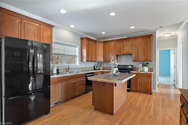 kitchen with a kitchen island, brown cabinets, light countertops, black appliances, and a sink