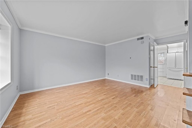 unfurnished living room with baseboards, light wood-style flooring, visible vents, and crown molding