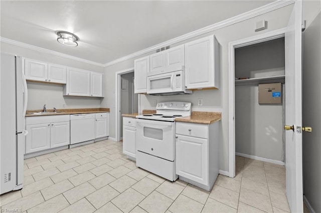 kitchen with crown molding, white appliances, white cabinets, and a sink