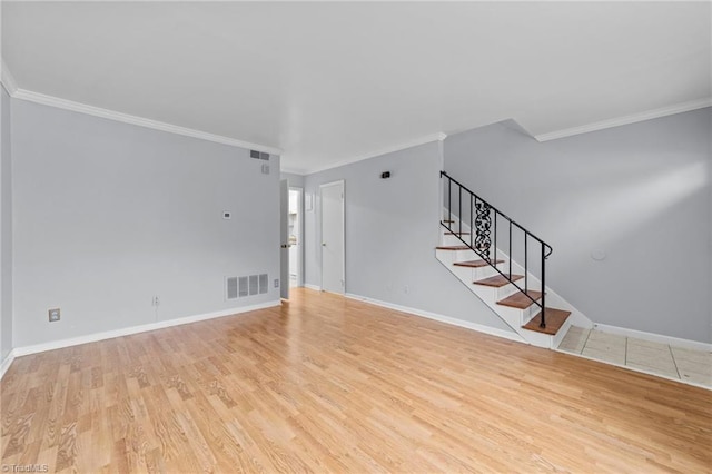 unfurnished living room with wood finished floors, visible vents, baseboards, ornamental molding, and stairway