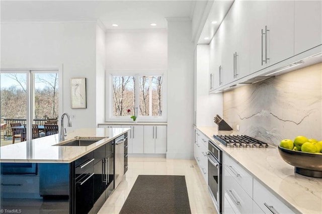 kitchen featuring a kitchen island with sink, sink, white cabinetry, and stainless steel appliances