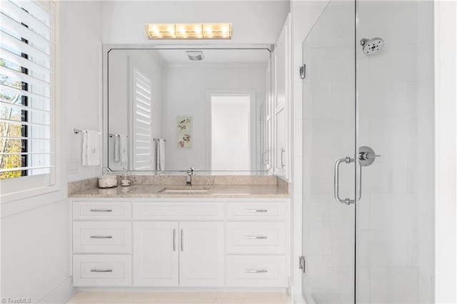 bathroom with a shower with shower door and vanity