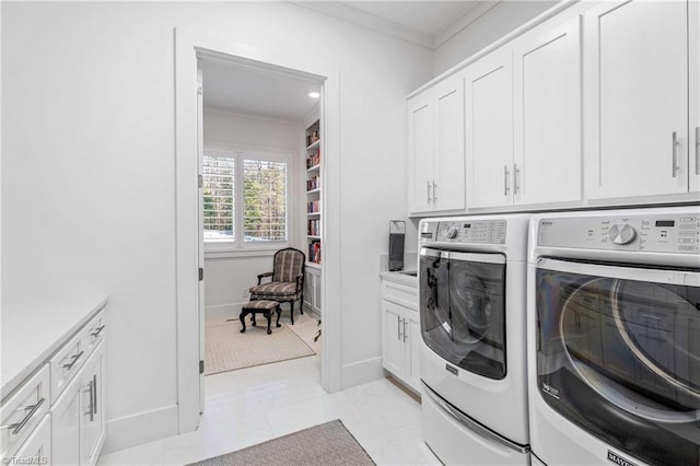 washroom with light tile patterned flooring, washer and dryer, ornamental molding, and cabinets