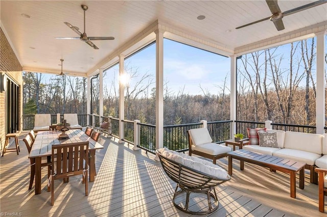 sunroom / solarium featuring ceiling fan, plenty of natural light, and wood ceiling