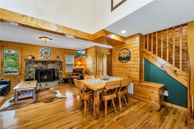 240 Deer Knoll Dr, Piney Creek, NC 28663 - dining area with wood finished floors, a fireplace, wooden walls, and a high ceiling