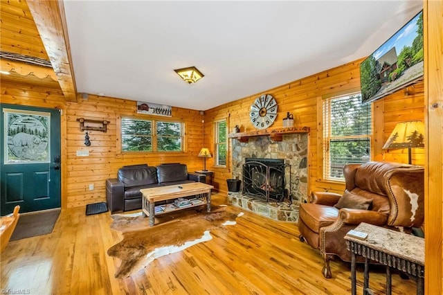 240 Deer Knoll Dr, Piney Creek, NC 28663 - living room with plenty of natural light, wood-type flooring, a stone fireplace, and wooden walls