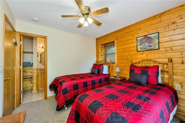 240 Deer Knoll Dr, Piney Creek, NC 28663 - carpeted bedroom featuring wood walls, ensuite bathroom, and a ceiling fan