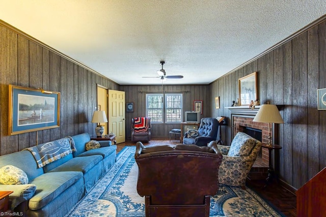 living area featuring a textured ceiling, a fireplace, a ceiling fan, and wood walls