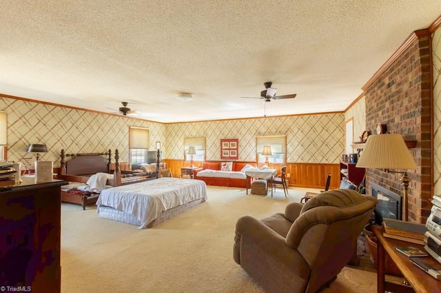 carpeted bedroom with wallpapered walls, ornamental molding, a fireplace, and a textured ceiling