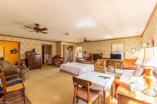 bedroom with carpet flooring, a textured ceiling, crown molding, and wallpapered walls