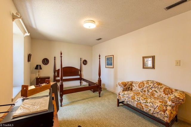 carpeted bedroom featuring visible vents, a textured ceiling, and baseboards