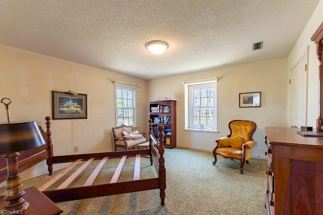 sitting room with visible vents, carpet floors, a textured ceiling, and baseboards