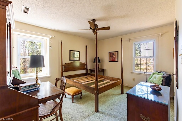 office featuring a wealth of natural light, visible vents, carpet, and a ceiling fan