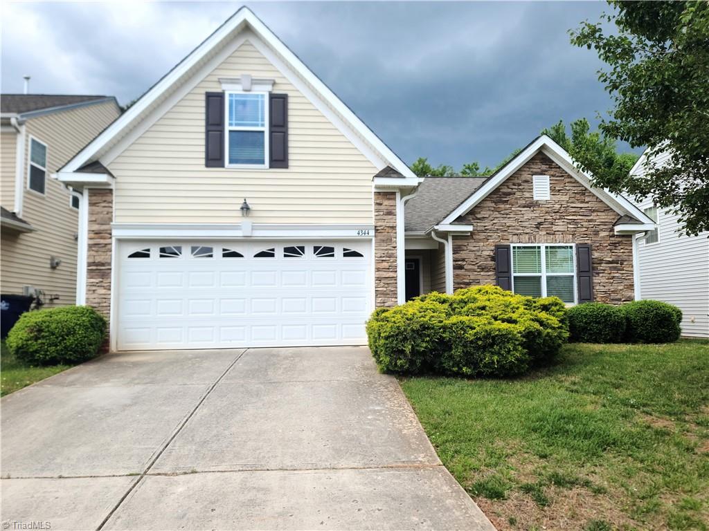 4344 Morning Ridge Ln, Winston-Salem, NC 27101 - traditional home featuring stone siding, driveway, and a front yard
