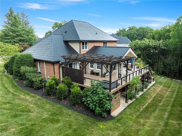 back of property featuring a wooden deck, a lawn, a pergola, and brick siding