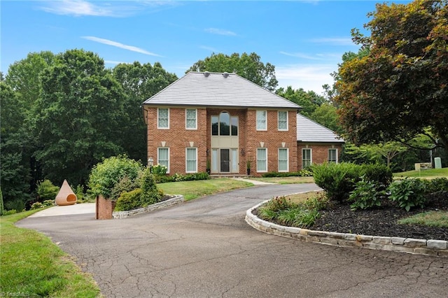 view of front of home featuring brick siding and a front lawn