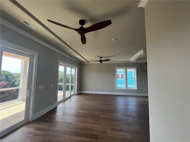 unfurnished room featuring ceiling fan, plenty of natural light, dark wood-type flooring, and crown molding