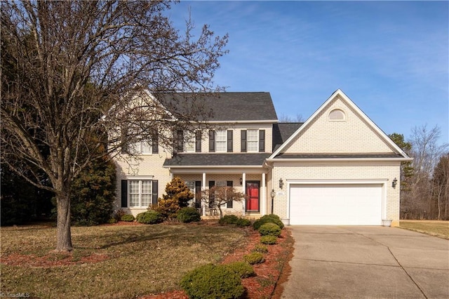 colonial inspired home featuring a porch, a garage, and a front lawn