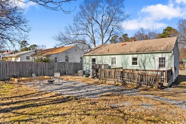 rear view of property with a fire pit and a deck