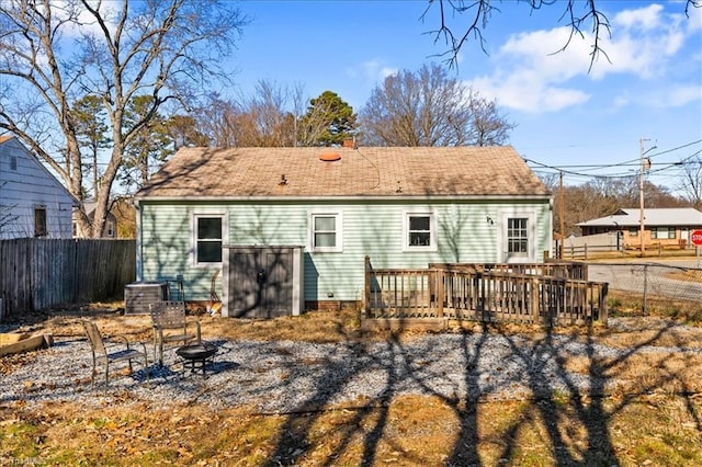 rear view of property featuring a fire pit and a deck