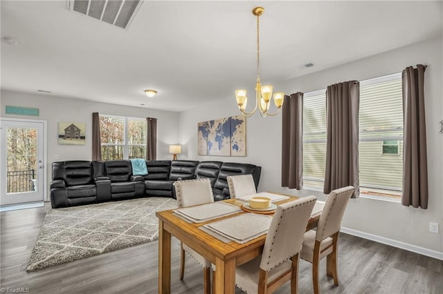 dining space featuring a notable chandelier, visible vents, and dark wood-type flooring