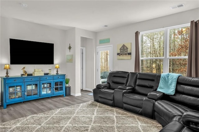 living room with visible vents, baseboards, and wood finished floors