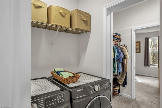 clothes washing area with carpet, laundry area, baseboards, and washing machine and clothes dryer