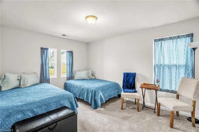 carpeted bedroom featuring visible vents and baseboards