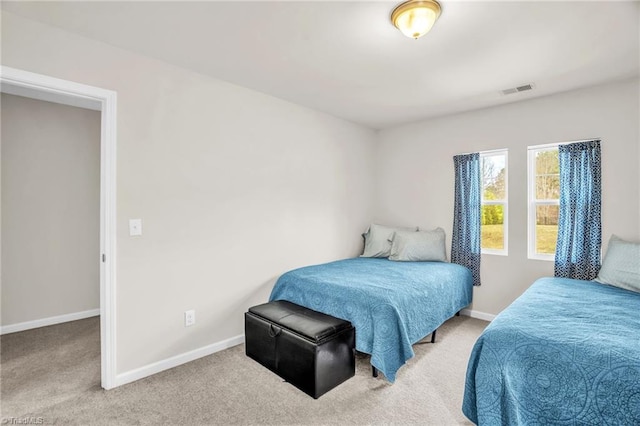 carpeted bedroom featuring visible vents and baseboards