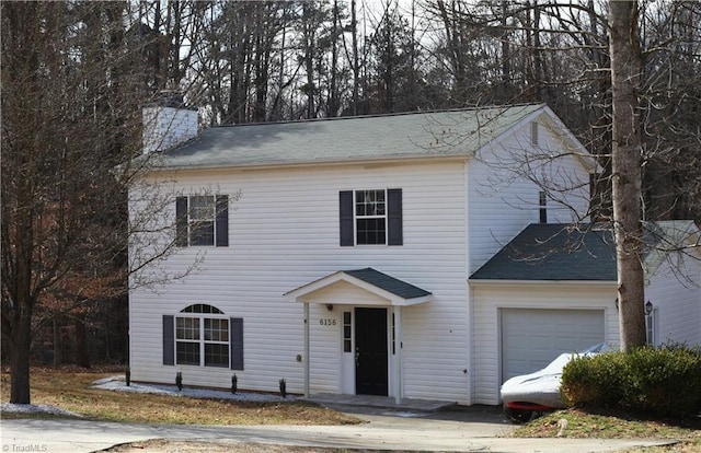 view of front of house featuring a chimney and an attached garage