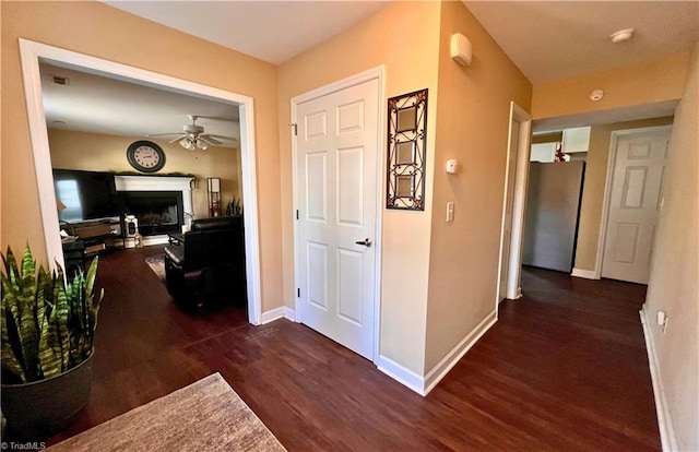 hall featuring dark wood-type flooring and baseboards