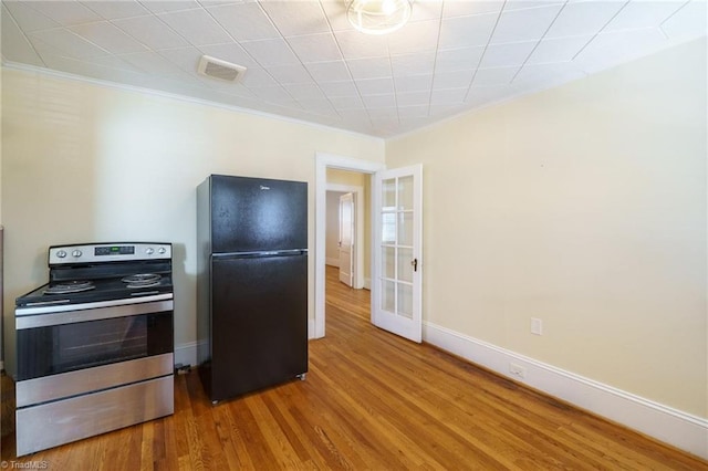 kitchen with visible vents, baseboards, stainless steel electric range oven, wood finished floors, and freestanding refrigerator