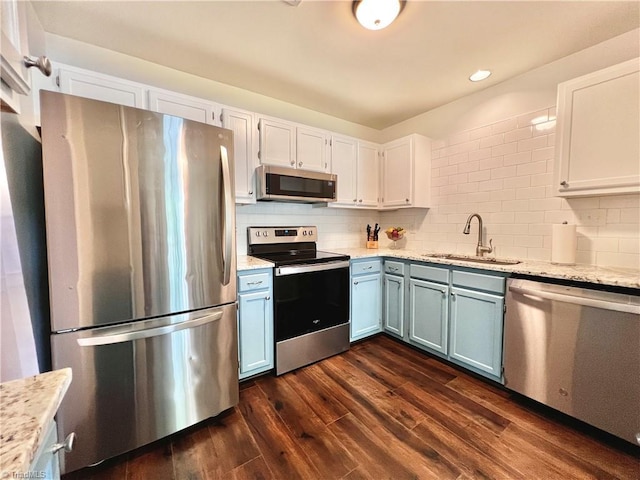 4003 Honey Locust Ct, Greensboro, NC 27410 - kitchen with stainless steel appliances, blue cabinetry, a sink, dark wood-type flooring, and white cabinetry