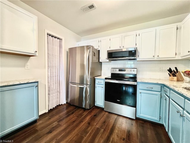 4003 Honey Locust Ct, Greensboro, NC 27410 - kitchen with stainless steel appliances, blue cabinets, dark wood finished floors, tasteful backsplash, and white cabinetry