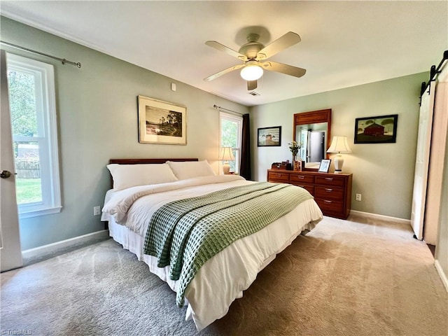 4003 Honey Locust Ct, Greensboro, NC 27410 - bedroom with light carpet, baseboards, a barn door, and a ceiling fan