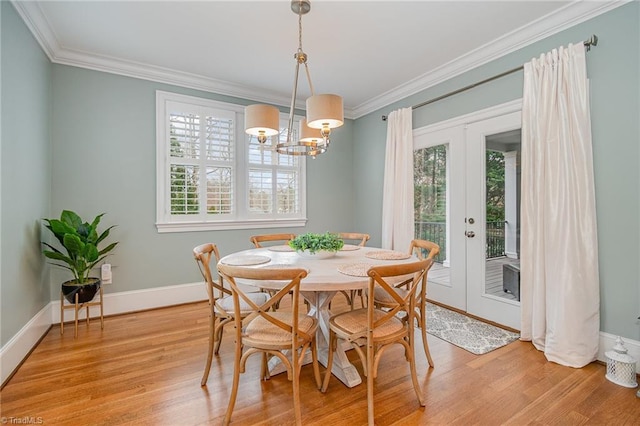 dining space featuring light wood-type flooring, plenty of natural light, and ornamental molding